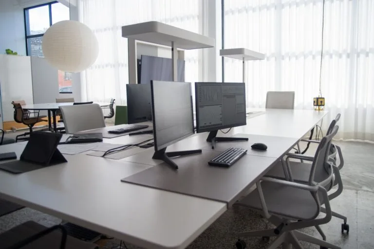 Open-plan office workstations with monitors and task chairs