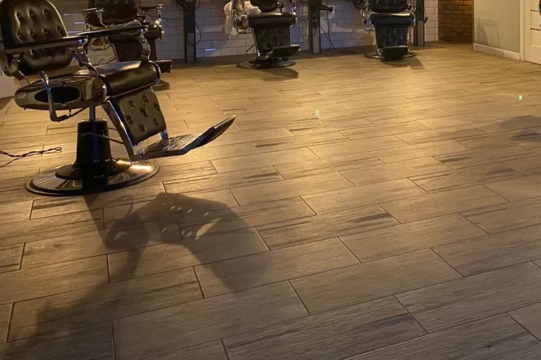 Barbershop interior with reclining barber chairs on wood-look porcelain tile