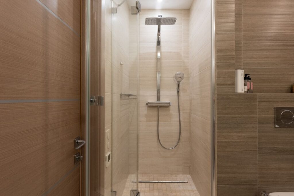 Frameless glass shower enclosure in a contemporary hotel bathroom