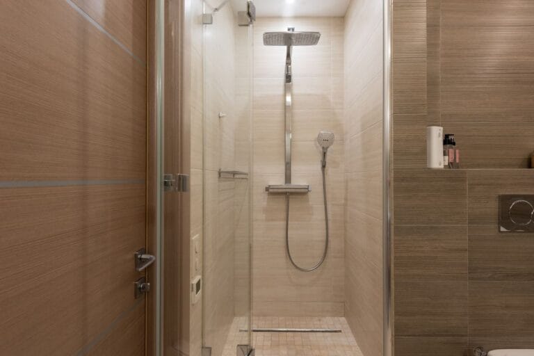 Frameless glass shower enclosure in a contemporary hotel bathroom