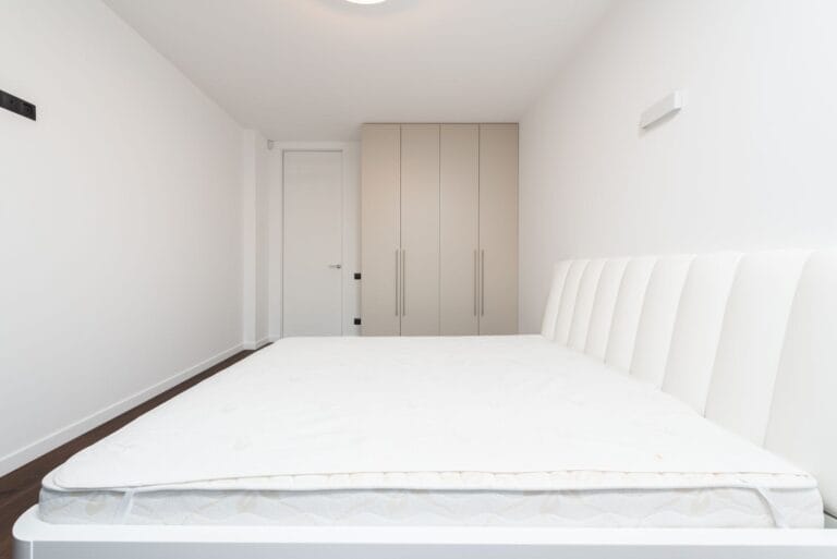 Bedroom with a new white mattress and built-in wardrobe