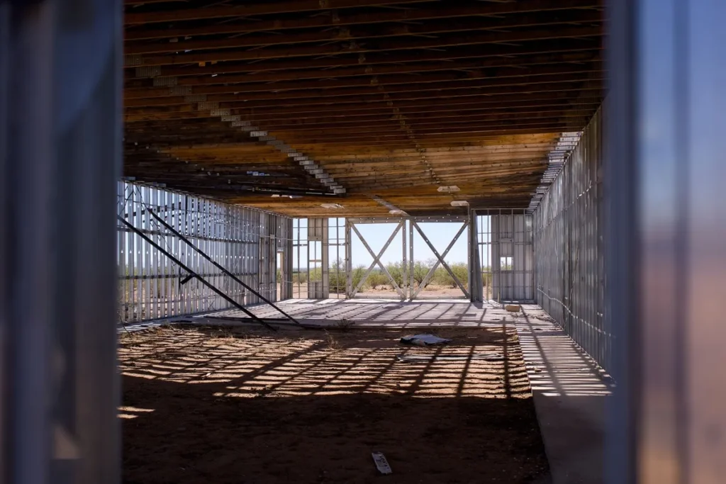 Light steel stud framing inside a building shell before drywall boards are fixed