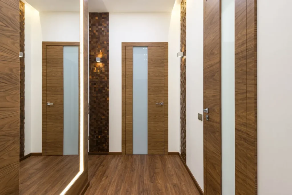 Apartment hallway with interior wood veneer doors and glass inserts