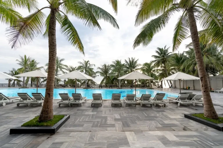 Resort pool deck with sun loungers and parasols, representing outdoor furniture for high-heat Middle East projects