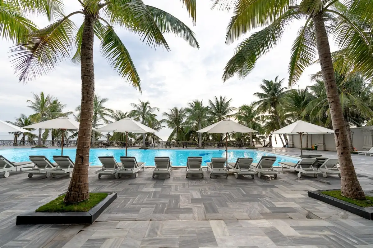 Resort pool deck with sun loungers and parasols, representing outdoor furniture for high-heat Middle East projects