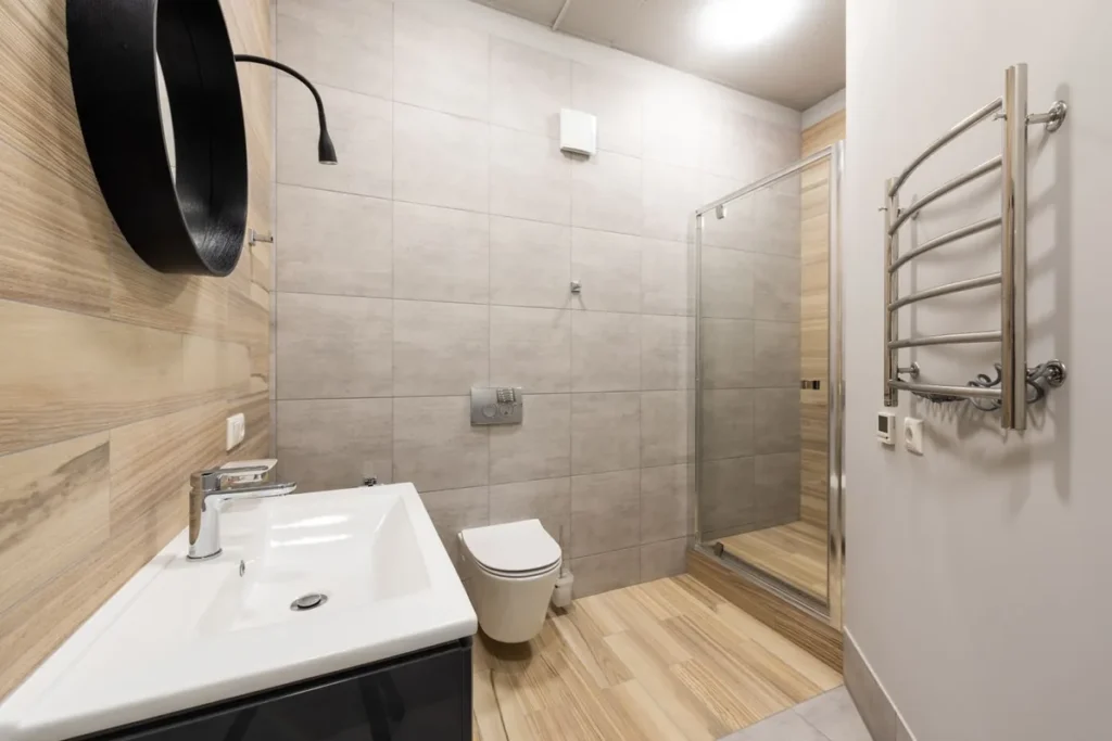 Bathroom with wall-hung toilet, basin mixer and shower screen, representing WaterMark sanitary ware for Australian projects