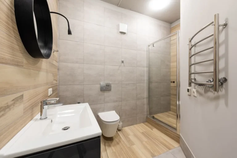 Bathroom with wall-hung toilet, basin mixer and shower screen, representing WaterMark sanitary ware for Australian projects