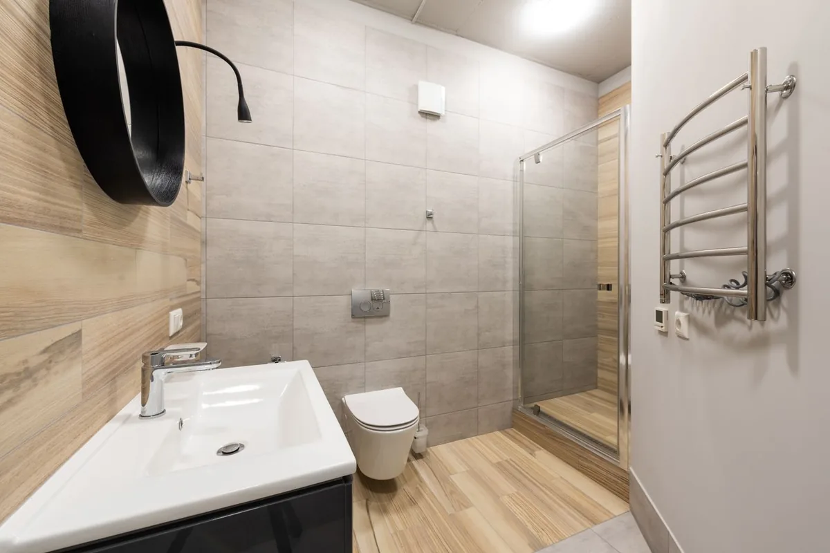 Bathroom with wall-hung toilet, basin mixer and shower screen, representing WaterMark sanitary ware for Australian projects