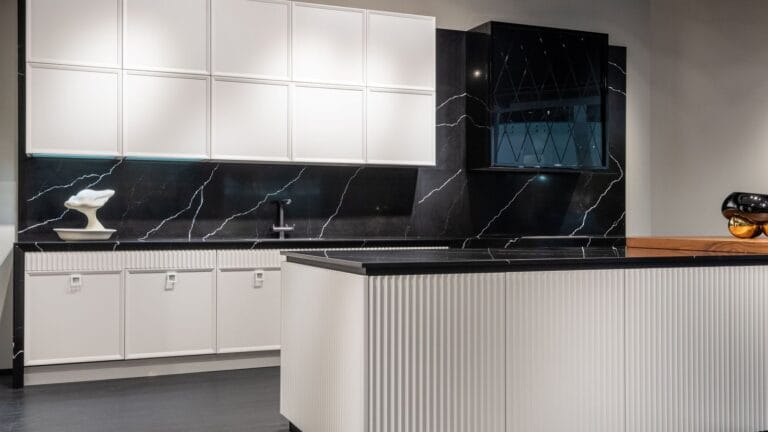 White kitchen cabinets with island and dark stone splashback