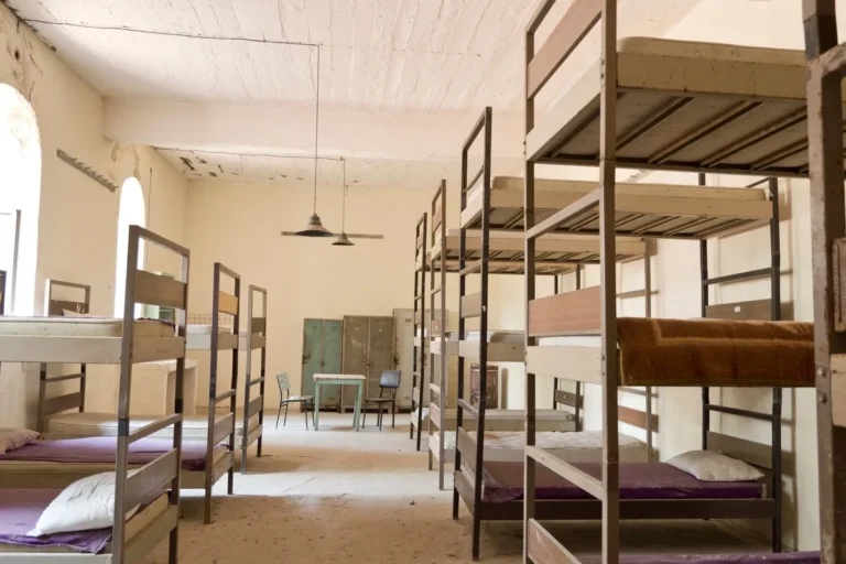 Steel-framed bunk beds and metal lockers in a shared staff accommodation room