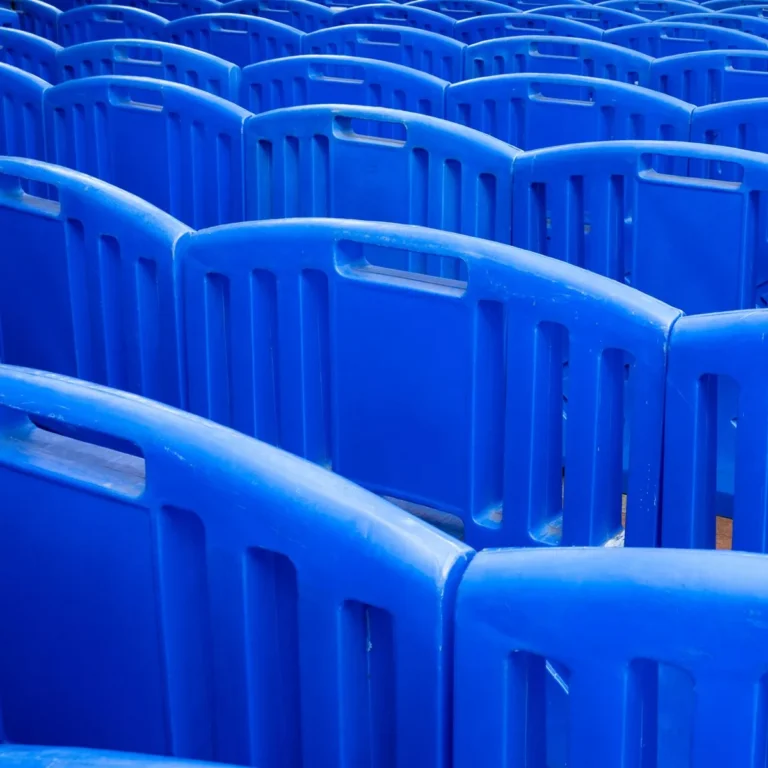 Rows of blue polypropylene shell chairs lined up in an event hall