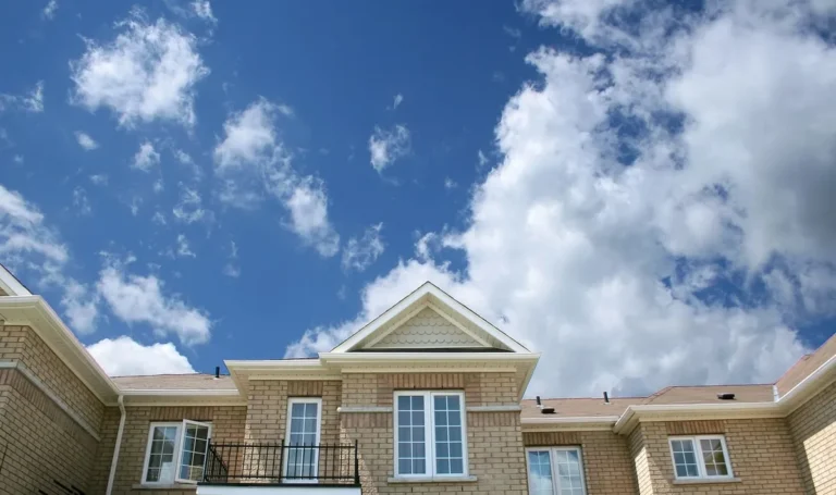 Brick house with white framed windows under a blue sky