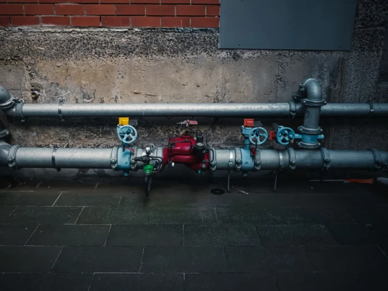 Building service pipework with isolation valves fixed along a concrete wall