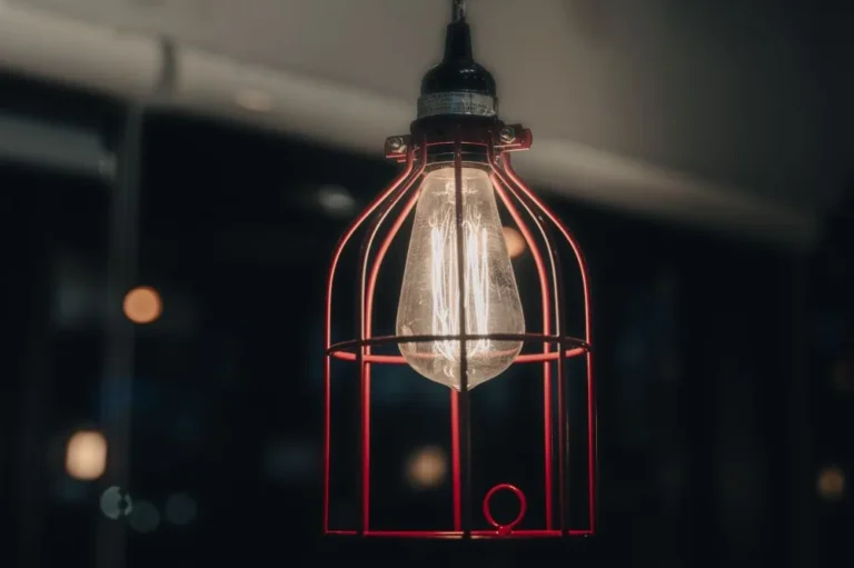 Cage pendant light with a bulb hanging indoors