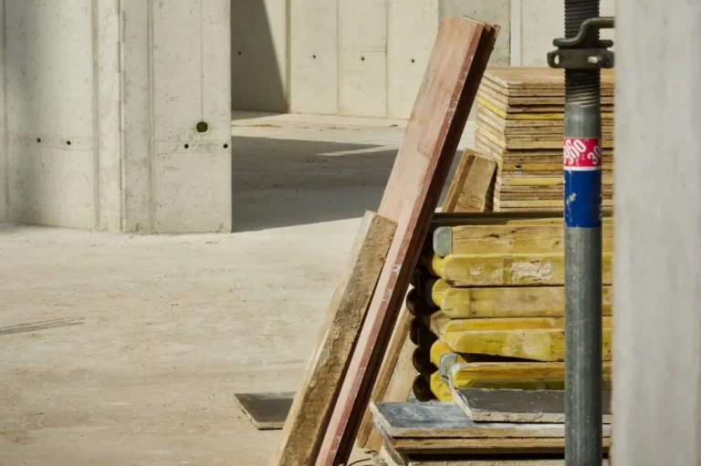 Concrete building interior with stacked boards and materials on site