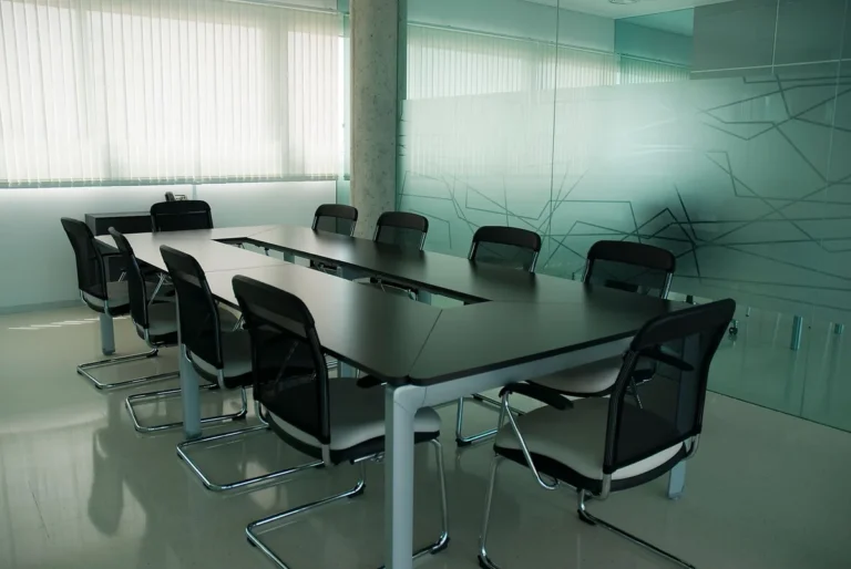 Conference room with black chairs behind a glass wall