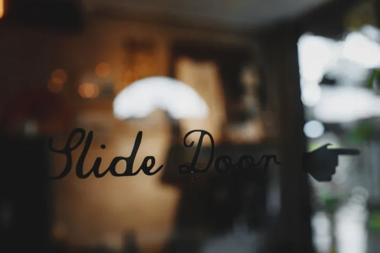 Glass door with a handwritten slide door sign and a blurred interior behind it