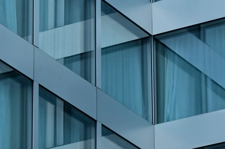 Glass building facade with metal framing and blue tinted panels