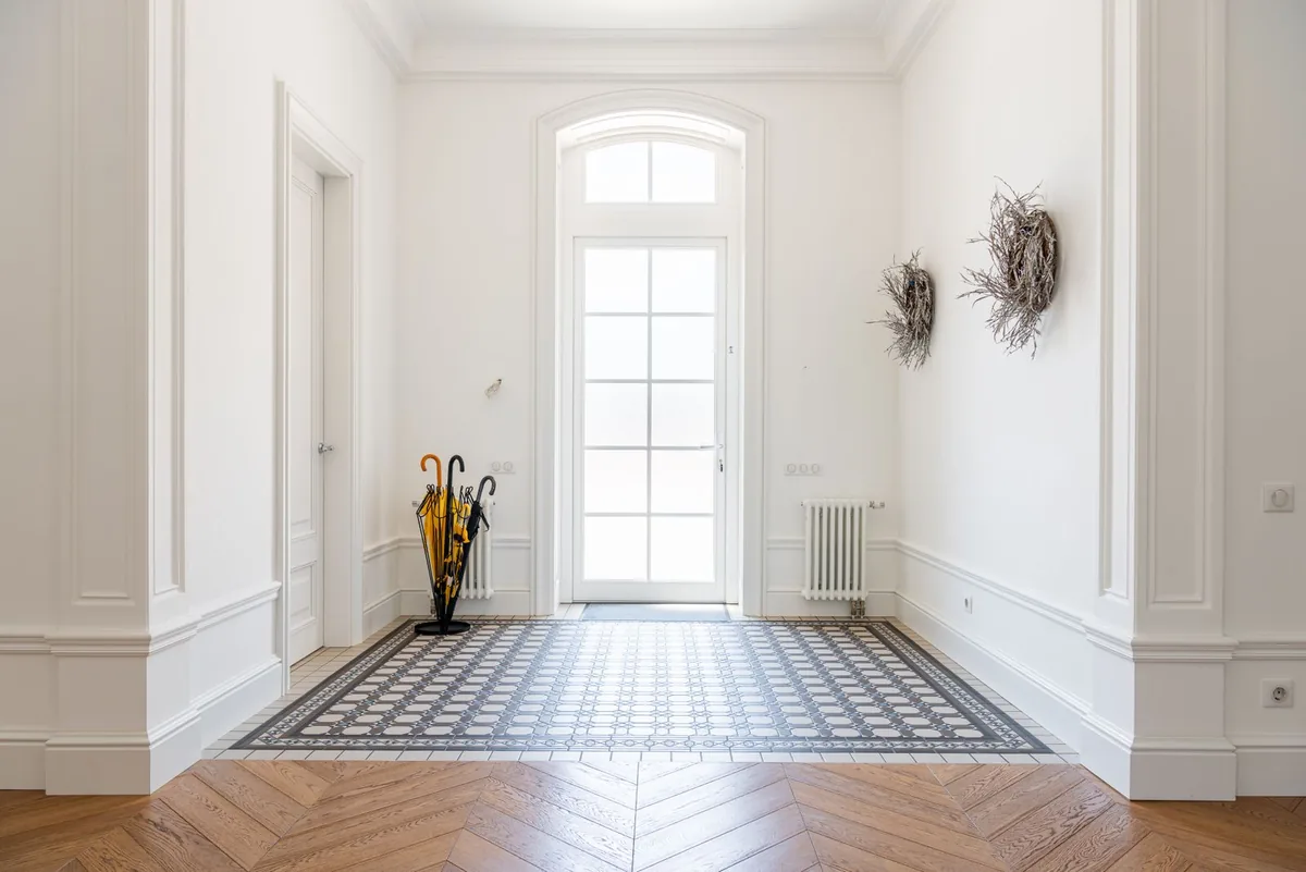 Hallway with parquet flooring and a tiled inset