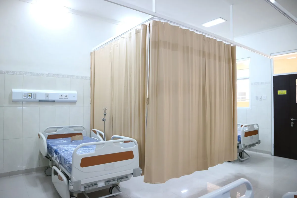 Hospital ward with beds and privacy curtains