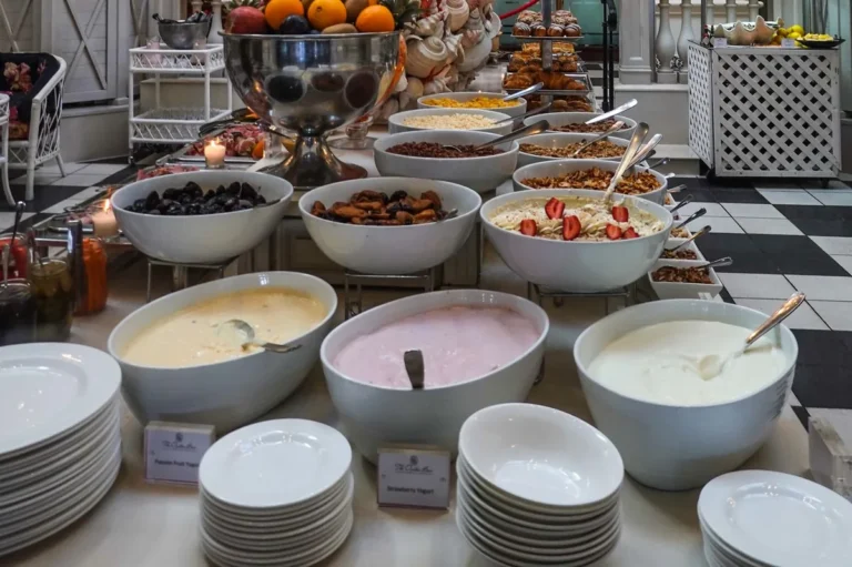 Hotel dining hall buffet with bowls and plates under a chandelier