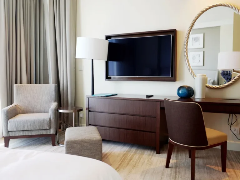 Hotel room with a credenza, armchair, ottoman and desk chair