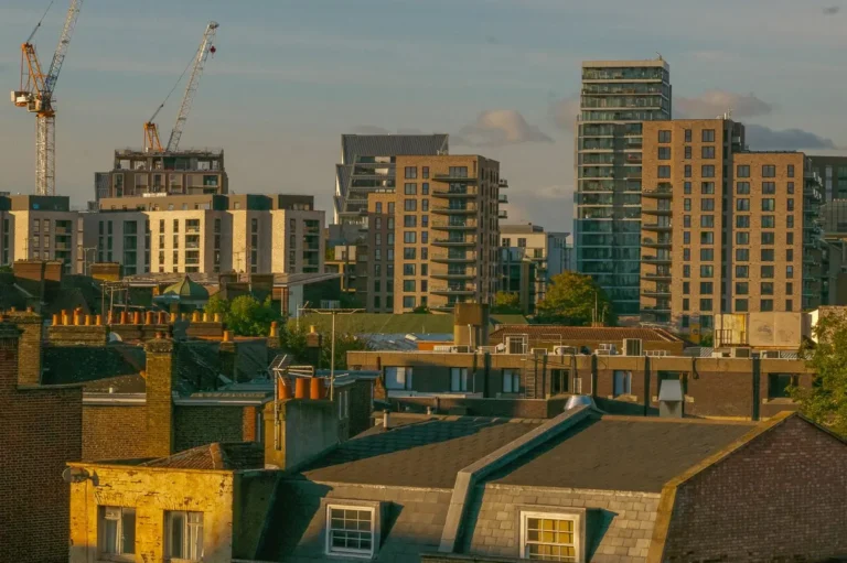 London skyline at dusk with construction cranes beside residential towers