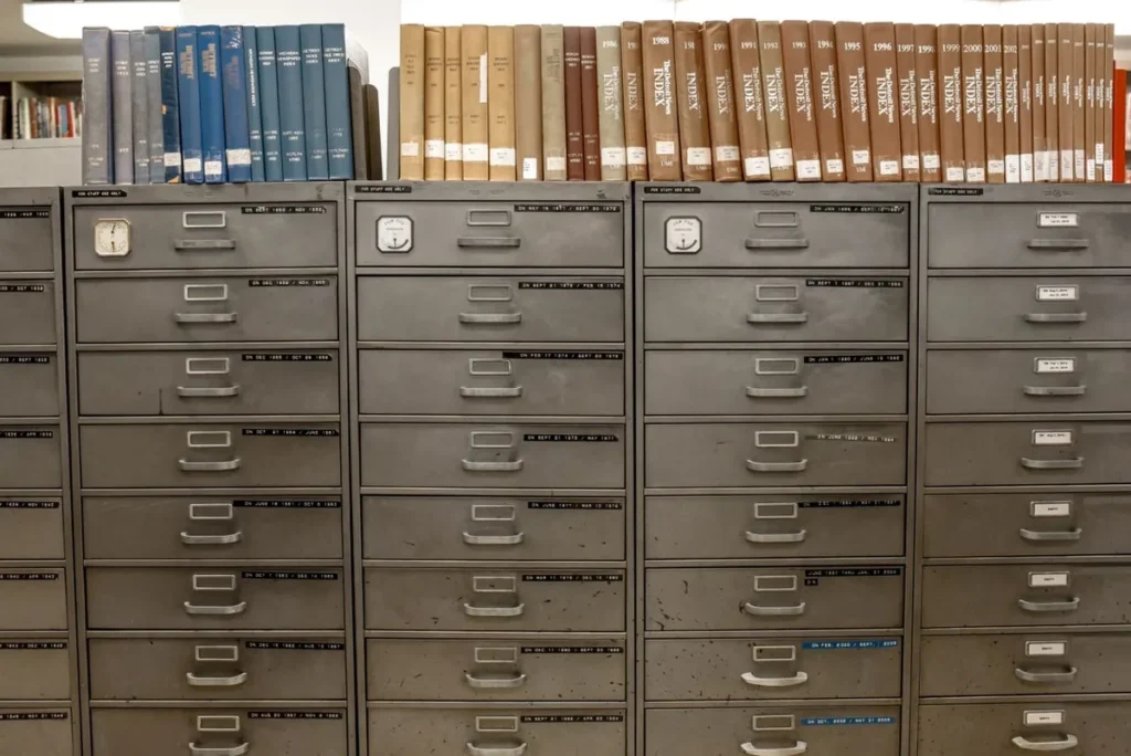 Rows of steel filing cabinet drawers with label holders in an archive room