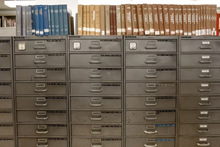 Rows of steel filing cabinet drawers with label holders in an archive room