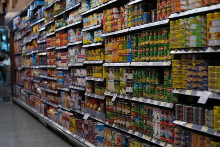 Supermarket shelving and gondola systems stocked in a grocery aisle.