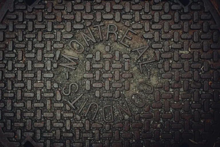 Close-up of a cast manhole cover with a raised grip pattern and lettering