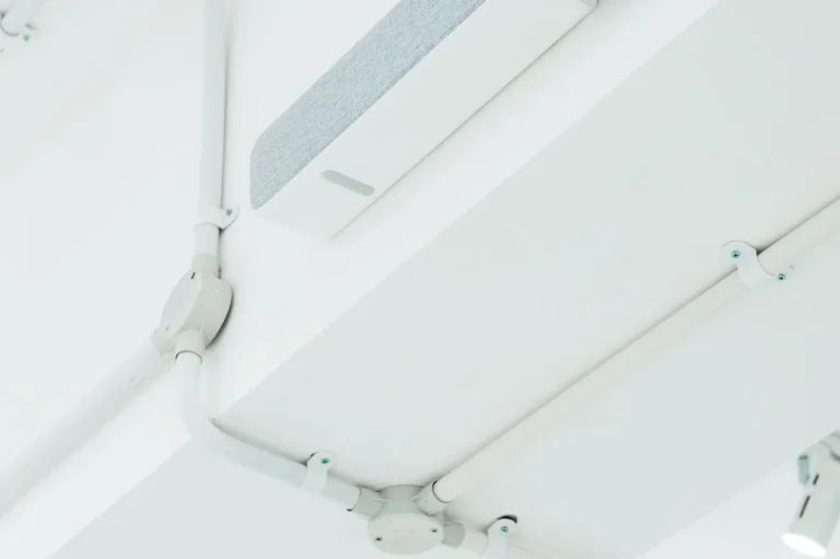 White ceiling with exposed surface-mounted electrical conduit and fittings