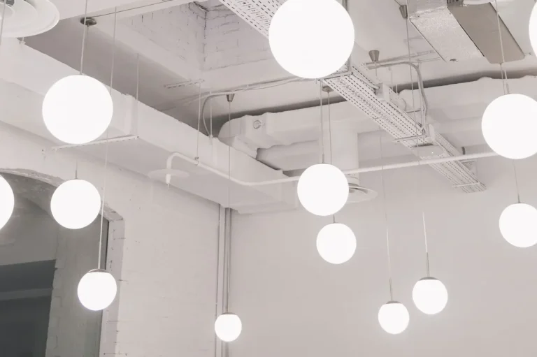 White ceiling with round pendant lights and a cable tray