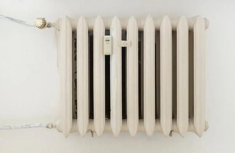 White metal radiator mounted on a plain wall
