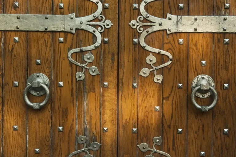 Close-up of wooden doors with decorative metal door hardware