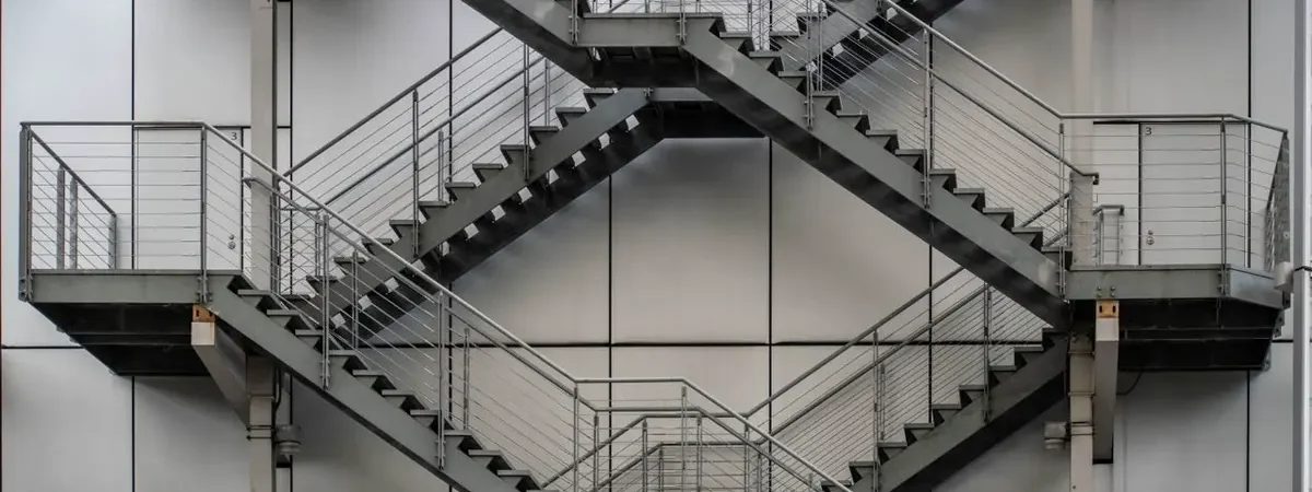 Welded steel switchback egress stairs on a commercial building - metal stairs sourcing from China