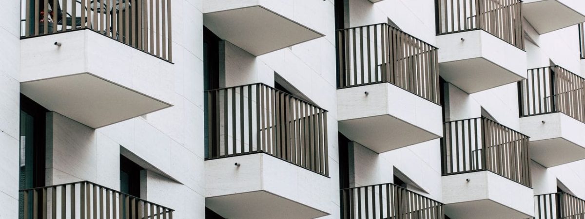 Urban apartment building with geometric balconies in modern architectural style.